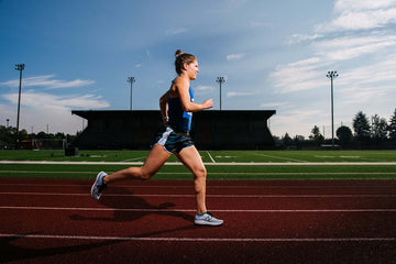 Woman running around track