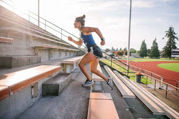 Fit woman running up bleacher stairs