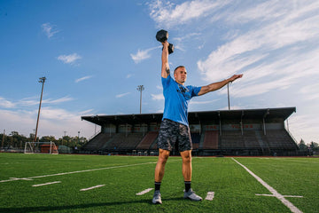 Man pressing one dumbbell overhead