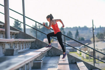 Fit young woman running up bleacher stairs
