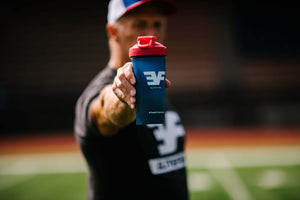 Man holding an Elite Fuel shaker bottle with an outstretched arm