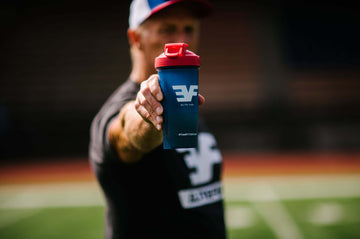 Man holding an Elite Fuel shaker bottle with an outstretched arm